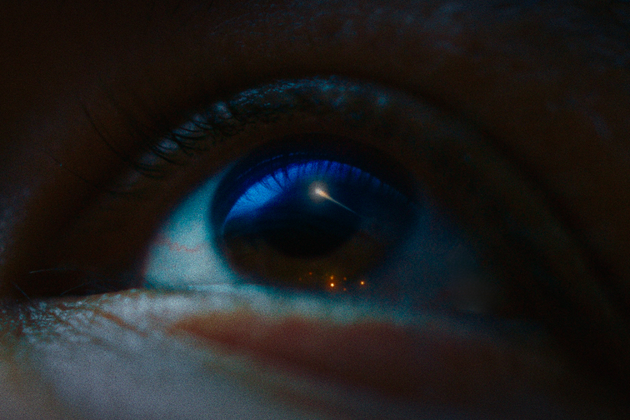 Kadr z filmu "My Name Is Hope". W źrenicy oka odbija się obiekt lecący na niebie.