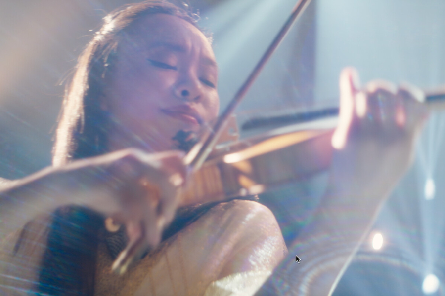 Kadr z filmu "One Note". Kobieta gra na skrzypcach w promieniach światła.