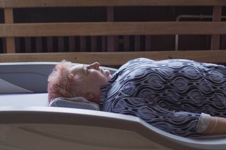 Kadr z filmu "Powtórzenia". Kobieta leży na urządzeniu rehabilitacyjnym.